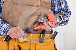 Repairman holding pipe wrench