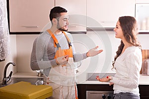 Repairman and housewife at kitchen