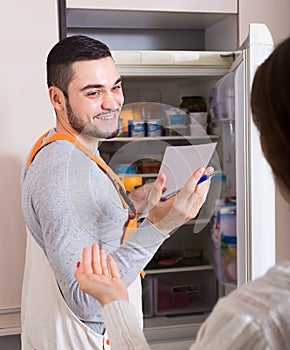 Repairman and housewife at kitchen