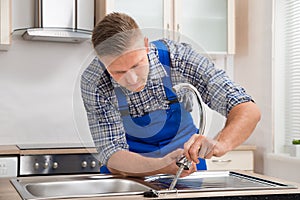 Repairman Installing Faucet Of Kitchen Sink