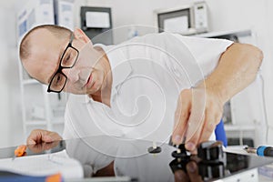 Repairman installing induction cooker in kitchen