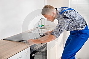 Repairman Installing Induction Cooker photo