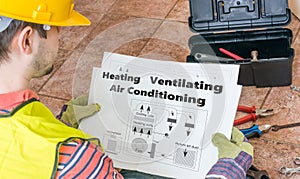 Repairman is looking at documentation of HVAC photo