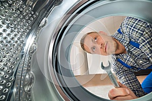 Repairman Looking Inside The Washing Machine