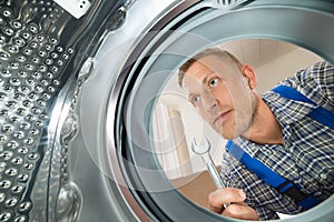 Repairman Looking Inside The Washing Machine