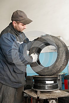 Repairman lubricating car tyre