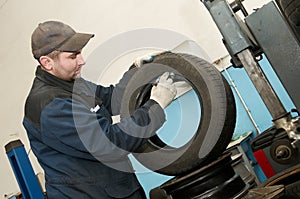 Repairman lubricating car tyre