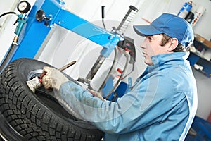 Repairman mechanic lubricating car tyre photo