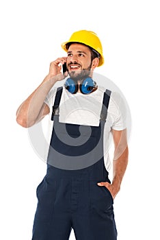 Repairman in overalls talking on smartphone isolated on white