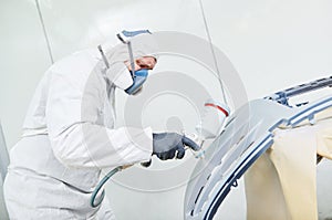 repairman painter in chamber painting automobile car bonnet