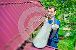 Repairman with a pipe to drain water from the roof