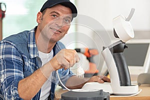 repairman plugging in coffee machine to test it