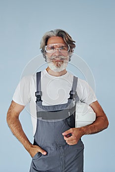 Repairman ready for work. Senior stylish modern man with grey hair and beard indoors
