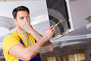 The repairman repairing ceiling air conditioning unit