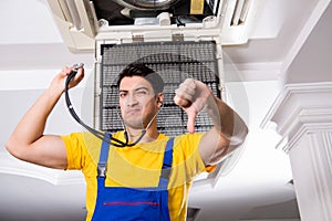 The repairman repairing ceiling air conditioning unit