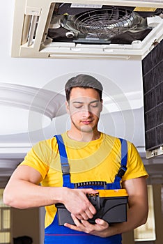 The repairman repairing ceiling air conditioning unit