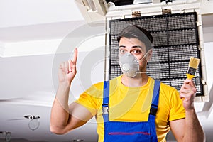 The repairman repairing ceiling air conditioning unit