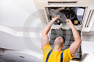 The repairman repairing ceiling air conditioning unit
