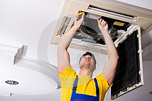 The repairman repairing ceiling air conditioning unit