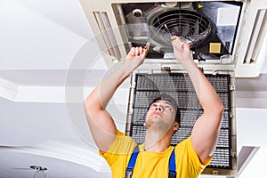 The repairman repairing ceiling air conditioning unit