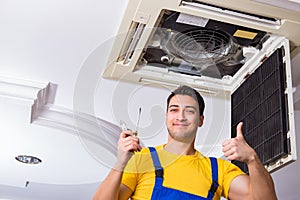 The repairman repairing ceiling air conditioning unit