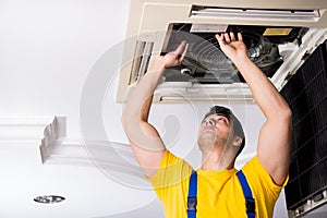 The repairman repairing ceiling air conditioning unit