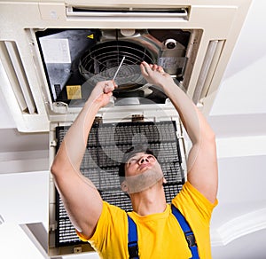 Repairman repairing ceiling air conditioning unit