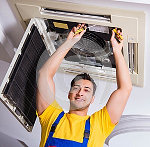 Repairman repairing ceiling air conditioning unit