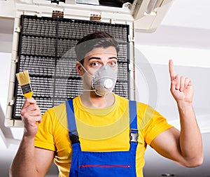 Repairman repairing ceiling air conditioning unit