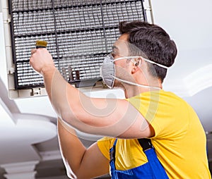 Repairman repairing ceiling air conditioning unit