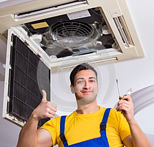 Repairman repairing ceiling air conditioning unit