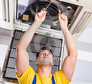 Repairman repairing ceiling air conditioning unit