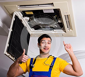 Repairman repairing ceiling air conditioning unit