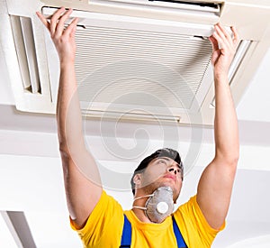 Repairman repairing ceiling air conditioning unit