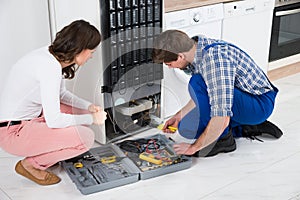 Repairman Repairing Refrigerator