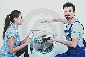 Repairman repairing washing machine for housewife.