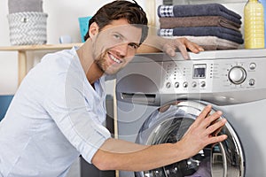 Repairman repairing washing machine in kitchen