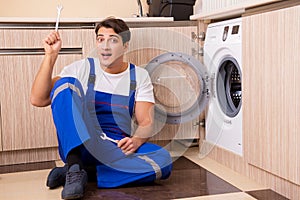 The repairman repairing washing machine at kitchen