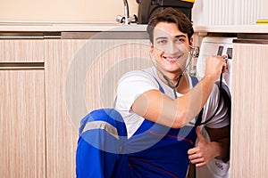 The repairman repairing washing machine at kitchen