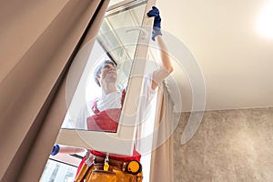 a repairman repairs, adjusts or installs metal-plastic windows in the apartment. glazing of balconies, loggias, verandas