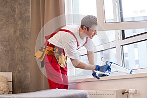 a repairman repairs, adjusts or installs metal-plastic windows in the apartment. glazing of balconies, loggias, verandas