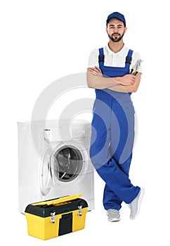 Repairman with toolbox near washing machine on background