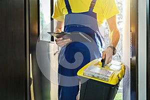 repairman with toolbox standing at home entrance