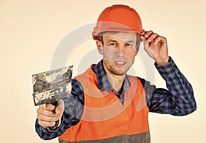 repairman in uniform. man use spatula tool. real construction worker in helmet. carpenter ready to work. building tool