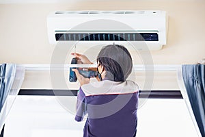 Repairman using a screwdriver fixing modern air conditioner, Male technician cleaning air conditioner indoors, Maintenance and