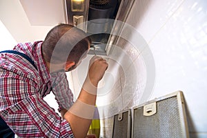 Repairman work on ventilation in the kitchen