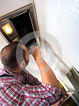 Repairman work on ventilation in the kitchen