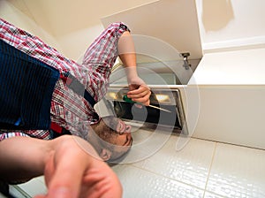 Repairman work on ventilation in the kitchen
