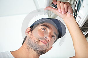 Repairman working on air conditioning unit
