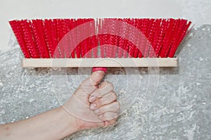 Repairman working with broom. painting and priming wall paint. hand hold fetlock on gray grunge cement wall background. brush for photo